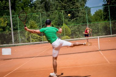 Sahada tenis oynayan genç atletik çift.