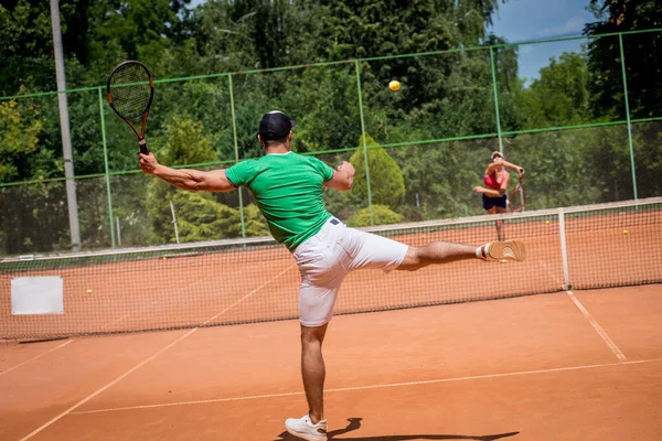 Młoda sportowa para grająca w tenisa na korcie. — Zdjęcie stockowe