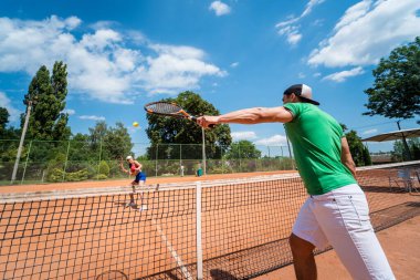 Sahada tenis oynayan genç atletik çift.