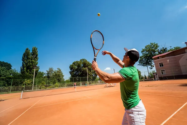 Sahada tenis oynayan genç bir atletik..