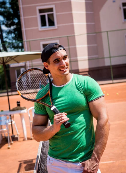 Porträt eines jungen, athletischen Mannes auf dem Tennisplatz. — Stockfoto