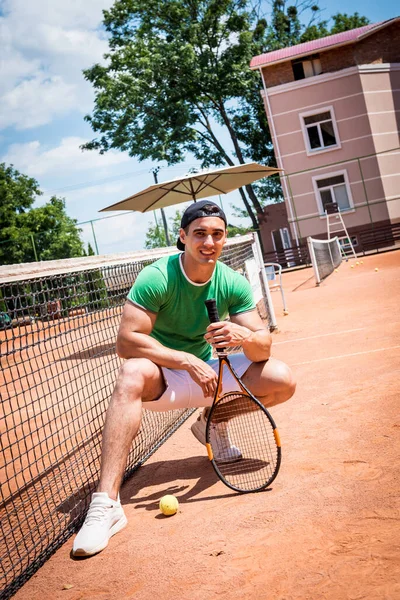 Porträtt av ung atletisk man på tennisbana. — Stockfoto