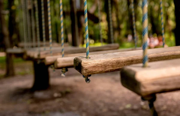 숲 속의 밧줄 공원에 다리를 놓으세요. 어드벤처 여름 공원. — 스톡 사진