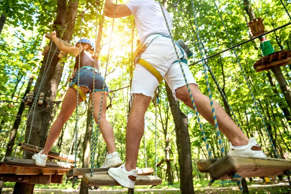 Junges Paar vergnügt sich im Abenteuer-Seilpark. — Stockfoto