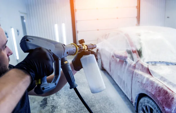 Arbeiter waschen Auto mit Aktivschaum in einer Waschanlage. — Stockfoto