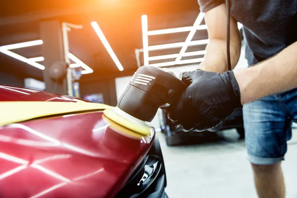 Trabajador de servicio de coches pule los detalles de un coche con pulidor orbital. —  Fotos de Stock