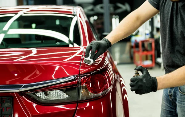 Bil servicearbetare tillämpa nano beläggning på en bil detalj. — Stockfoto