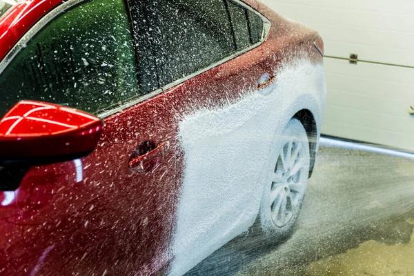 Trabajador de lavado de coches con espuma activa en un lavado de coches. — Foto de Stock