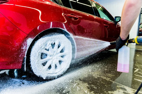 Limpieza de la rueda del coche con un cepillo y agua — Foto de Stock