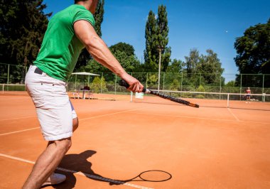 Sahada tenis oynayan genç bir atletik..