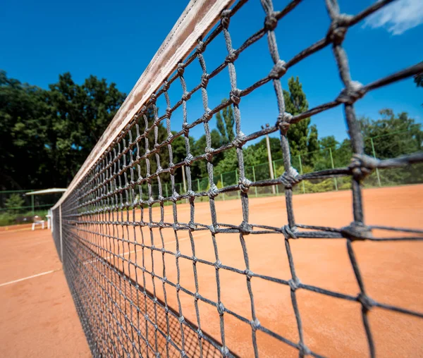 Red de tenis en pista de arcilla roja con líneas y sombras. — Foto de Stock