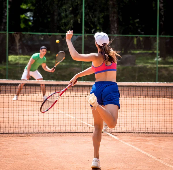 Sahada tenis oynayan genç atletik çift.