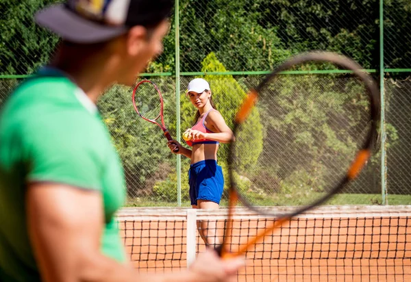 Junges Sportlerpaar spielt Tennis auf dem Platz. — Stockfoto