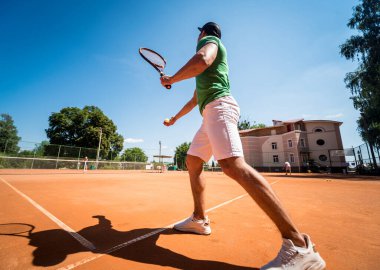 Sahada tenis oynayan genç bir atletik..