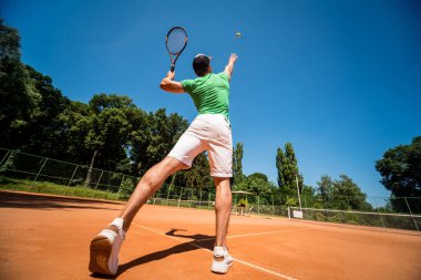 Sahada tenis oynayan genç bir atletik..