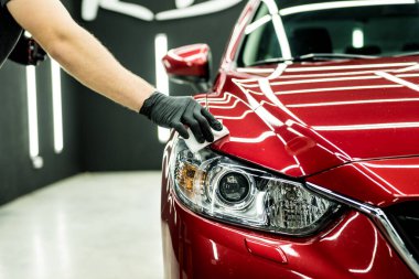 Araba servisi çalışanı bir araba detayına nano kaplama uyguluyor..