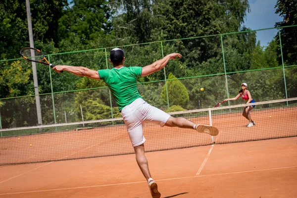 Sahada tenis oynayan genç atletik çift.