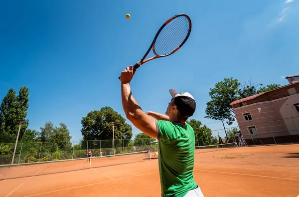 Sahada tenis oynayan genç bir atletik..
