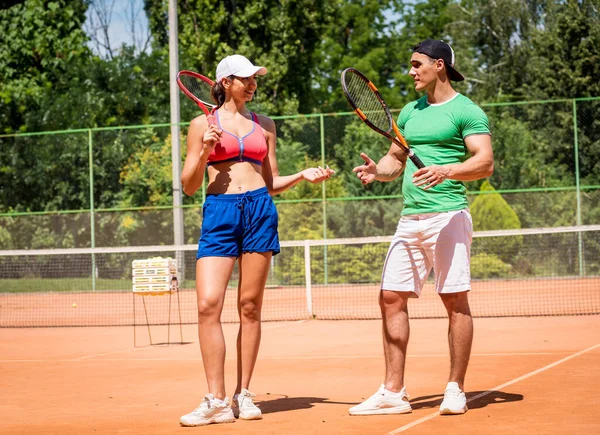 Молода спортсменка грає в теніс зі своїм тренером . — стокове фото