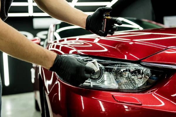 Trabajador de servicio de coches aplicando nano recubrimiento en un detalle del coche. — Foto de Stock