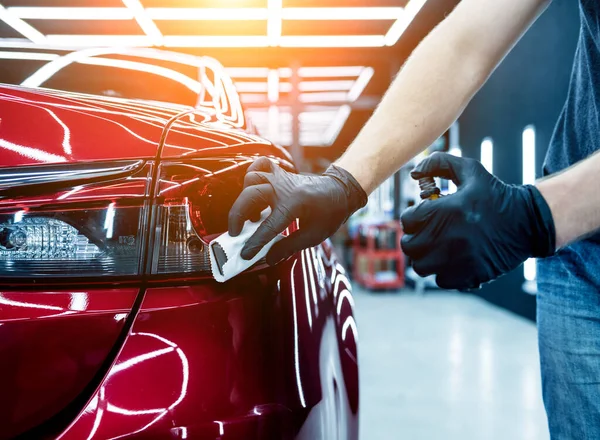 Trabajador de servicio de coches aplicando nano recubrimiento en un detalle del coche. — Foto de Stock