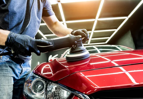 Il lavoratore di servizio d'auto lucida dettagli d'auto con lucidatore orbitale. — Foto Stock