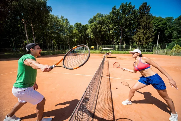 Sahada tenis oynayan genç atletik çift.