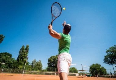 Sahada tenis oynayan genç bir atletik..