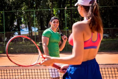 Sahada tenis oynayan genç atletik çift.