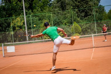Sahada tenis oynayan genç atletik çift.