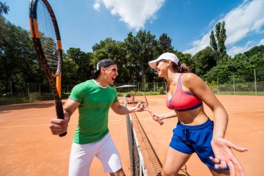 Sahada tenis oynayan genç atletik çift.