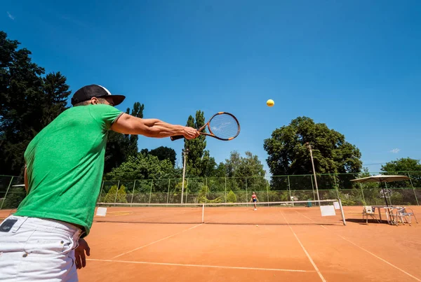 Młody sportowiec gra w tenisa na korcie. — Zdjęcie stockowe