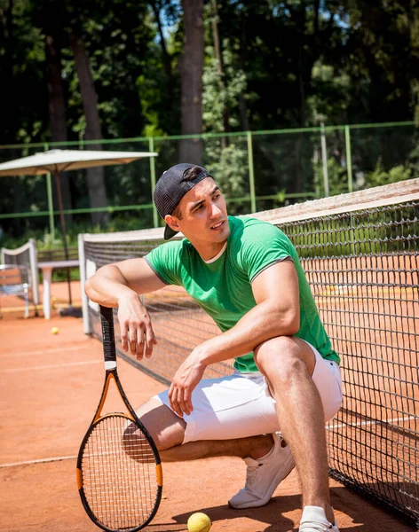 Porträtt av ung atletisk man på tennisbana. — Stockfoto