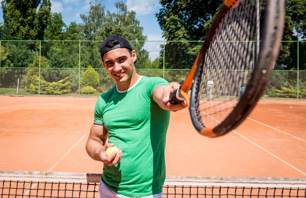 Porträt eines jungen, athletischen Mannes auf dem Tennisplatz. — Stockfoto
