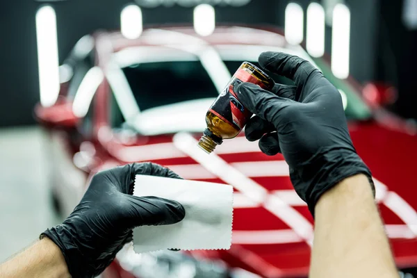 Trabajador de servicio de coches aplicando nano recubrimiento en un detalle del coche. —  Fotos de Stock