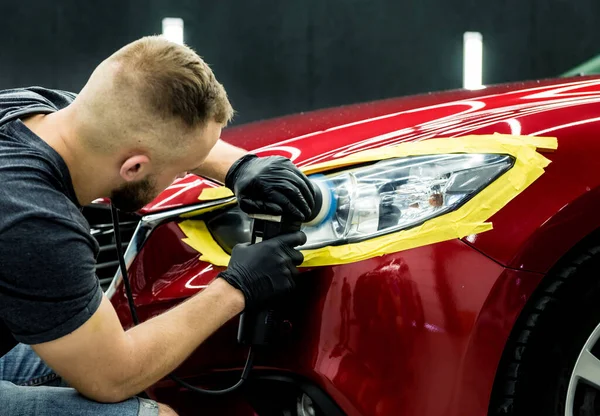 Autoservice-Mitarbeiter poliert ein Auto mit Orbitalpolierer. — Stockfoto