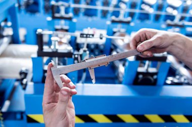 Erkek eller, her kalibreyi tutar ve çelik tasmayı ölçer..