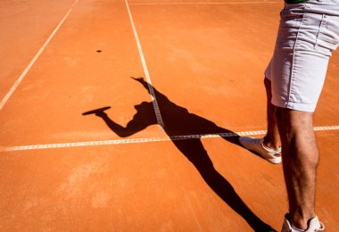 Sahada tenis oynayan genç bir atletik..