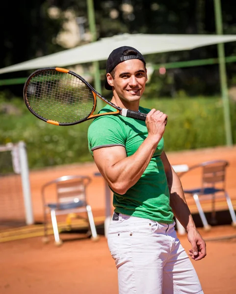Porträtt av ung atletisk man på tennisbana. — Stockfoto
