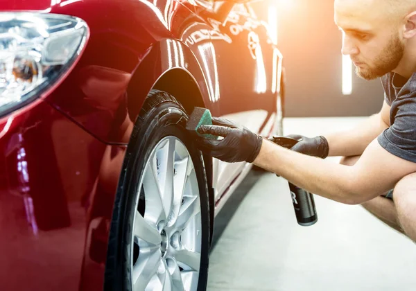 Autoservice-Mitarbeiter poliert Autoräder mit Mikrofasertuch. — Stockfoto