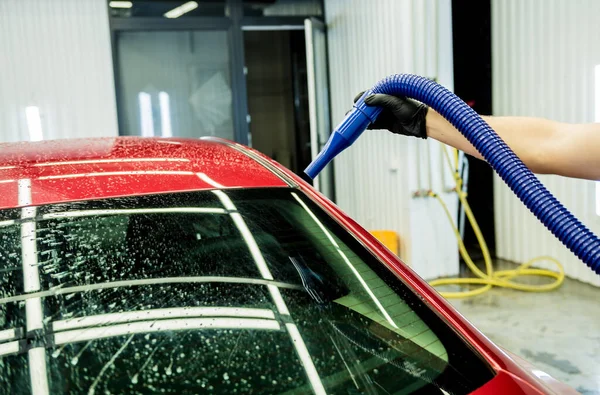 Pracownik serwisu wykonuje automatyczne suszenie samochodu po umyciu. — Zdjęcie stockowe
