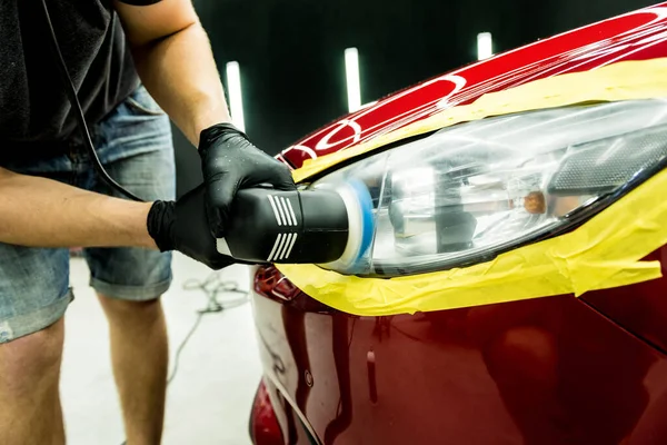 Trabajador de servicio de coches pule los detalles de un coche con pulidor orbital. —  Fotos de Stock