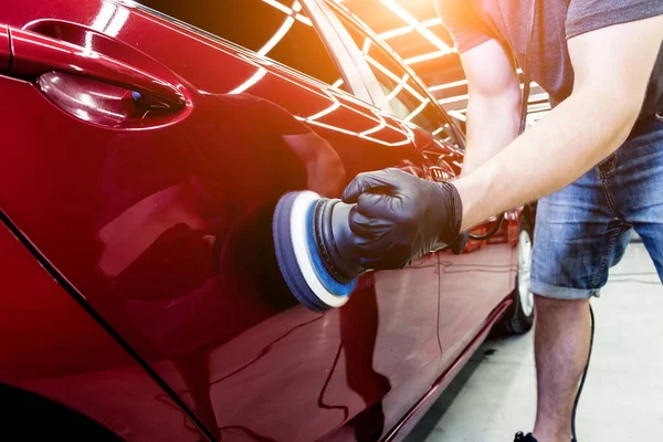 Autoservice-Mitarbeiter poliert ein Auto mit Orbitalpolierer. — Stockfoto