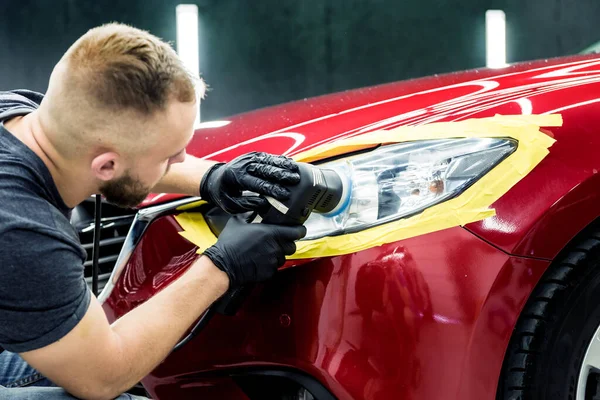 Autoservice-Mitarbeiter poliert ein Auto mit Orbitalpolierer. — Stockfoto