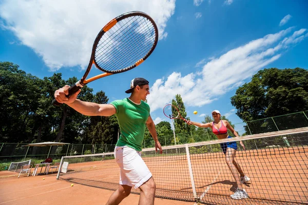 코트에서 테니스를 치고 있는 젊은 운동 부부. — 스톡 사진
