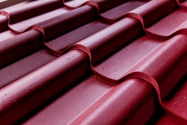 Kırmızı metalik çatı kiremitleri ve su damlaları.