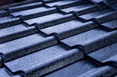 Mavi metalik çatı kiremitleri ve su damlaları.