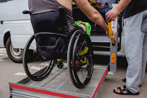 Uomo disabile su sedia a rotelle con veicolo accessibile con meccanismo di sollevamento. — Foto Stock