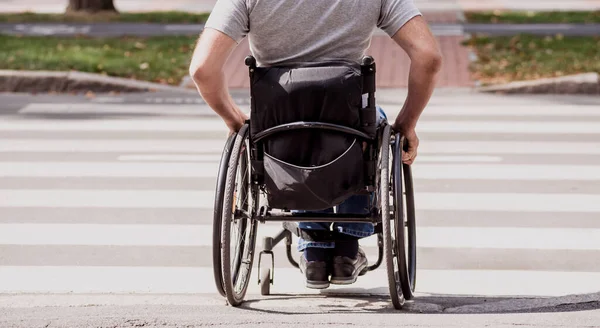 Handicapped man in wheelchair crossing street road — Stock Photo, Image