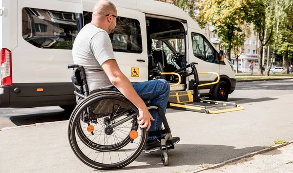 Un hombre en silla de ruedas se traslada al ascensor de un vehículo especializado —  Fotos de Stock